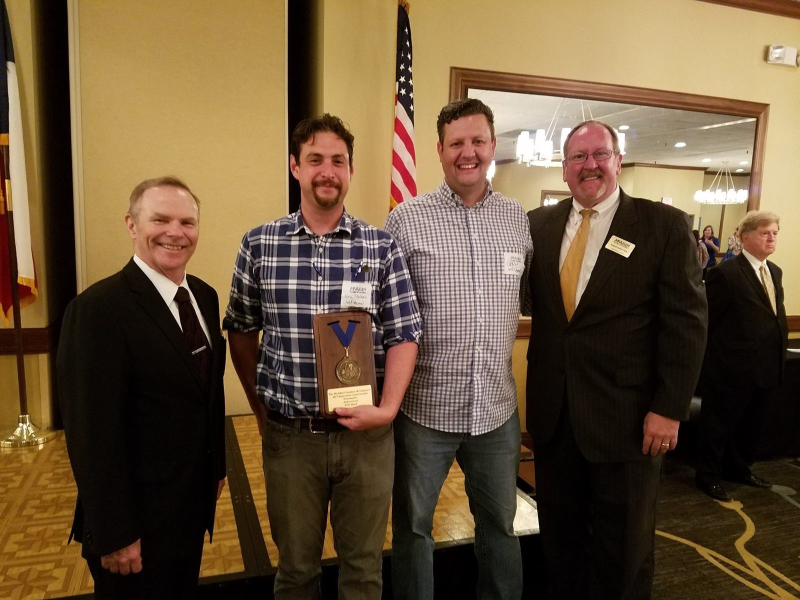 Drew Lentz receiving the McAllen Chamber Innovation Award with the mayor and chamber director